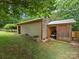 Shed featuring wood paneling, silver metallic roof, and lush green yard at 3042 Cresthill Dr, Charlotte, NC 28212