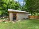 View of shed featuring wood paneling, silver metallic roof, and lush green yard at 3042 Cresthill Dr, Charlotte, NC 28212