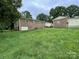 A large backyard with grass area, fenced with brick buildings at 311 Tiffany Nw St, Concord, NC 28027