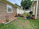 Backyard brick sheds, table with chairs, and potted plants, framed by a mulched border at 311 Tiffany Nw St, Concord, NC 28027