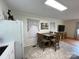 Functional kitchen and dining area with white cabinets, a refrigerator, and a wooden dining set at 311 Tiffany Nw St, Concord, NC 28027