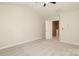 Simple, spacious bedroom with plush carpet and a door leading to the stairway at 3349 Ellingford Rd, Charlotte, NC 28214