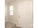Bright entryway featuring a white front door, neutral walls, and carpeted stairs at 3349 Ellingford Rd, Charlotte, NC 28214