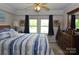 Bedroom with a wooden dresser, a ceiling fan, two windows with dark curtains, and neutral-colored walls at 3505 Valley Dr, Chester, SC 29706