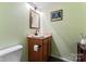 Compact half bathroom with a wooden vanity and a simple mirror, perfect for guests' convenience at 3520 Colony Rd # D, Charlotte, NC 28211