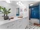 Bright, modern bathroom with dual sinks, sleek white cabinets, and blue tiled shower for spa-like experience at 3520 Colony Rd # D, Charlotte, NC 28211