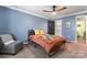 Cozy bedroom with blue walls, a ceiling fan, and an attached bathroom, creating a relaxing retreat at 3520 Colony Rd # D, Charlotte, NC 28211
