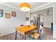 Cozy dining room with wood table, modern chandelier, and view to the stainless steel kitchen at 3520 Colony Rd # D, Charlotte, NC 28211