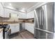 Open kitchen featuring stainless steel refrigerator, granite countertops, and modern appliances at 3520 Colony Rd # D, Charlotte, NC 28211