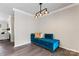 Stylish living room featuring a blue velvet sofa, modern lighting, and wood floors at 3520 Colony Rd # D, Charlotte, NC 28211
