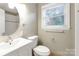 Bright bathroom featuring a white vanity, sink, and toilet at 3624 Moultrie St, Charlotte, NC 28209