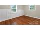 Charming bedroom featuring hardwood floors, wainscoting, and natural light at 3624 Moultrie St, Charlotte, NC 28209