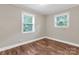 Cozy bedroom with hardwood floors, neutral walls, and two windows at 3624 Moultrie St, Charlotte, NC 28209