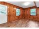 This bedroom features wood paneling and floors with windows at 3624 Moultrie St, Charlotte, NC 28209