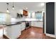 Well-lit kitchen with white cabinets, stainless steel appliances, island, and hardwood floors at 3624 Moultrie St, Charlotte, NC 28209