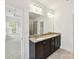 Bathroom featuring double sinks with granite counters, dark cabinets, and a large mirror at 4732 Water Oak Rd, Charlotte, NC 28211