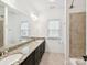 Bathroom featuring a double sink vanity, a full mirror and neutral tiled shower for a clean look at 4732 Water Oak Rd, Charlotte, NC 28211