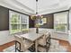Elegant dining room with modern chandelier, gray walls, white wainscoting, and a tray ceiling at 4732 Water Oak Rd, Charlotte, NC 28211