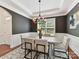 This dining room features a modern chandelier, dark grey accent wall, and an outdoor view at 4732 Water Oak Rd, Charlotte, NC 28211
