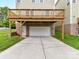 Ground level view of a two car garage beneath a raised deck, with brick and siding at 4732 Water Oak Rd, Charlotte, NC 28211