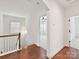Hallway featuring hardwood floors, white walls, and natural light, leading to various rooms at 4732 Water Oak Rd, Charlotte, NC 28211