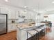 Bright kitchen with a large island, marble countertops, white cabinets, stainless steel appliances, and an open dining area at 4732 Water Oak Rd, Charlotte, NC 28211