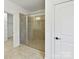 Walk-in shower with neutral tile, a glass door, and modern fixtures, located next to walk-in closet at 4732 Water Oak Rd, Charlotte, NC 28211