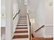 Staircase with wooden steps, white risers, and a classic banister, blending style and functionality at 4732 Water Oak Rd, Charlotte, NC 28211