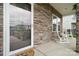 Inviting front porch featuring stone accents, rocking chairs, and a decorative door that creates a welcoming entrance at 500 Cedar Knoll Cir, Pineville, NC 28134