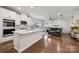 Open kitchen and living room featuring stainless appliances, white cabinets, and hardwood floors at 500 Cedar Knoll Cir, Pineville, NC 28134
