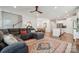 Open-concept living room with hardwood floors, plush gray sectional, and adjacent dining area at 500 Cedar Knoll Cir, Pineville, NC 28134