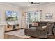Cozy living room with hardwood floors, ceiling fan, a gray sectional, and bright natural light at 500 Cedar Knoll Cir, Pineville, NC 28134
