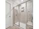 Walk-in shower with neutral tile, glass door, and built-in shelving at 500 Cedar Knoll Cir, Pineville, NC 28134