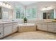 Bright bathroom with corner tub, tile surround, and double vanities and sinks for added convenience at 5805 Copperleaf Commons Ct, Charlotte, NC 28277