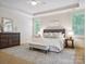 Spacious main bedroom with large rug, tray ceiling, bench, and large windows that let in natural light at 5805 Copperleaf Commons Ct, Charlotte, NC 28277