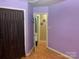 Bedroom with wood floors and purple walls, with doorway to another room at 5816 Rocky Mount Ct, Charlotte, NC 28214