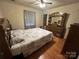 Comfortable bedroom featuring a wood floor and a classic wood dresser with a large mirror at 5816 Rocky Mount Ct, Charlotte, NC 28214