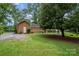 Brick home with a well manicured lawn, landscaping, and mature trees at 5926 Sharon Rd, Charlotte, NC 28210