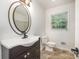 Bathroom with oval mirror, vanity and natural light from a window at 5926 Sharon Rd, Charlotte, NC 28210