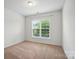 Well-lit bedroom featuring neutral carpet and a large window providing ample natural light at 6007 Edinburgh Ln # 214, Indian Land, SC 29707