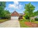 Beautiful brick home featuring a two-car garage, lush landscaping, and a well-manicured lawn, creating a picturesque setting at 6007 Edinburgh Ln # 214, Indian Land, SC 29707