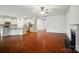 Spacious open-concept layout with hardwood floors, a fireplace, and a view of the kitchen featuring white cabinets and granite counters at 6007 Edinburgh Ln # 214, Indian Land, SC 29707