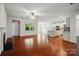 Open-concept living area with hardwood floors, fireplace, neutral walls, and a view of the kitchen with white cabinets at 6007 Edinburgh Ln # 214, Indian Land, SC 29707