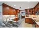 Well-lit kitchen featuring granite countertops, stainless steel appliances, and wood cabinetry at 635 Portside Dr, Davidson, NC 28036