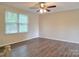 Bright bedroom with wood-look floors, a ceiling fan, and a large window for natural light at 7021 Willow Bend Ln, Mint Hill, NC 28227