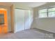 Bedroom with neutral walls, carpeted floors, a window, and closet at 7021 Willow Bend Ln, Mint Hill, NC 28227