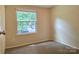 Cozy bedroom featuring carpet floors, neutral paint, and a window with outside views at 7021 Willow Bend Ln, Mint Hill, NC 28227