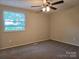 Comfortable bedroom with carpet, a ceiling fan, neutral walls, and a window overlooking trees at 7021 Willow Bend Ln, Mint Hill, NC 28227