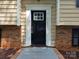 Home's exterior features a striking black front door framed by white trim and brick accents at 7021 Willow Bend Ln, Mint Hill, NC 28227