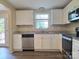 Bright kitchen featuring white cabinets, stainless steel appliances, granite countertops, and luxury vinyl floors at 7021 Willow Bend Ln, Mint Hill, NC 28227